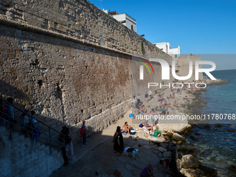 Swimmers relax in the warm Mediterranean waters on a sunny Sunday afternoon in Monopoli, Italy, on October 27, 2024. This image shows the co...