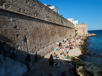 Swimmers relax in the warm Mediterranean waters on a sunny Sunday afternoon in Monopoli, Italy, on October 27, 2024. This image shows the co...