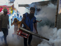 A worker sprays pesticide to kill mosquitoes at a slum in the capital city of Dhaka, Bangladesh. The country records 1,705 dengue-related de...