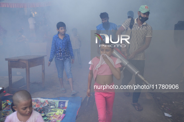 A worker sprays pesticide to kill mosquitoes at a slum in the capital city of Dhaka, Bangladesh. The country records 1,705 dengue-related de...