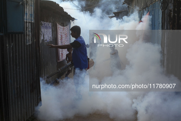 A worker sprays pesticide to kill mosquitoes at a slum in the capital city of Dhaka, Bangladesh. The country records 1,705 dengue-related de...