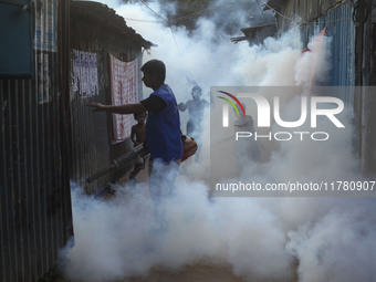 A worker sprays pesticide to kill mosquitoes at a slum in the capital city of Dhaka, Bangladesh. The country records 1,705 dengue-related de...