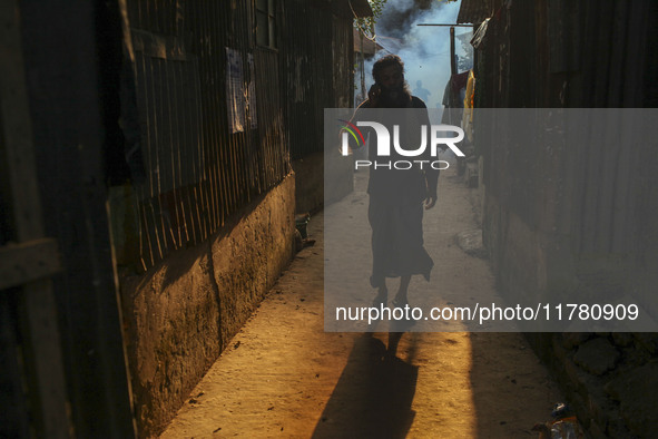 A man walks through the smoke at a slum in Dhaka, Bangladesh. A worker sprays pesticide to kill mosquitoes. The country records 1,705 dengue...