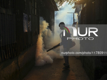 A worker sprays pesticide to kill mosquitoes at a slum in the capital city of Dhaka, Bangladesh. The country records 1,705 dengue-related de...