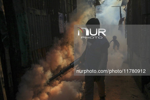 A worker sprays pesticide to kill mosquitoes at a slum in the capital city of Dhaka, Bangladesh. The country records 1,705 dengue-related de...