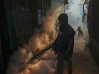 A worker sprays pesticide to kill mosquitoes at a slum in the capital city of Dhaka, Bangladesh. The country records 1,705 dengue-related de...