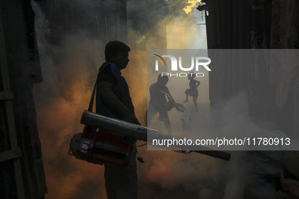 A worker sprays pesticide to kill mosquitoes at a slum in the capital city of Dhaka, Bangladesh. The country records 1,705 dengue-related de...