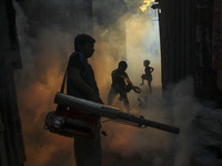 A worker sprays pesticide to kill mosquitoes at a slum in the capital city of Dhaka, Bangladesh. The country records 1,705 dengue-related de...