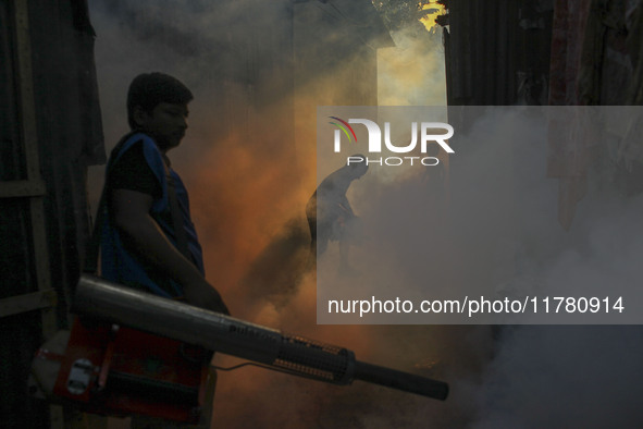 A worker sprays pesticide to kill mosquitoes at a slum in the capital city of Dhaka, Bangladesh. The country records 1,705 dengue-related de...