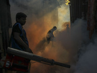 A worker sprays pesticide to kill mosquitoes at a slum in the capital city of Dhaka, Bangladesh. The country records 1,705 dengue-related de...