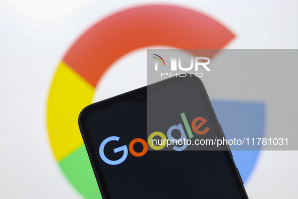 The Google logo appears on a smartphone screen and on the computer screen in the background in Reno, United States, on November 15, 2024. 