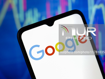 The Google logo appears on a smartphone screen, and in the background, a stock market graph is visible on the computer screen, in Reno, Unit...