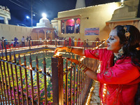 A woman lights earthen lamps at the Shrine Galtaji temple holy pond 'kund' as part of the Deep Mahotsav celebration on the eve of Dev Deepaw...