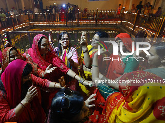 In Jaipur, Rajasthan, India, on November 15, 2024, people dance after lighting earthen lamps at the Shrine Galtaji temple holy pond 'kund' a...