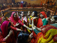 In Jaipur, Rajasthan, India, on November 15, 2024, people dance after lighting earthen lamps at the Shrine Galtaji temple holy pond 'kund' a...