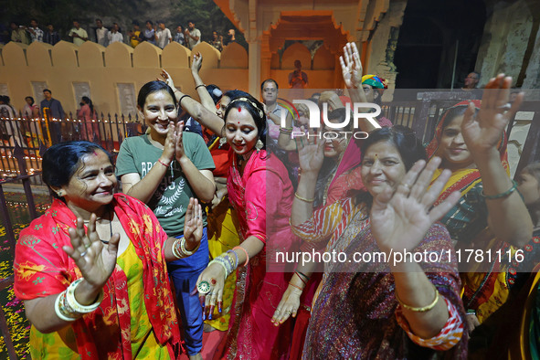 In Jaipur, Rajasthan, India, on November 15, 2024, people dance after lighting earthen lamps at the Shrine Galtaji temple holy pond 'kund' a...