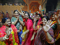 In Jaipur, Rajasthan, India, on November 15, 2024, people dance after lighting earthen lamps at the Shrine Galtaji temple holy pond 'kund' a...