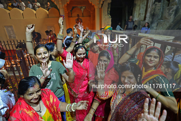 In Jaipur, Rajasthan, India, on November 15, 2024, people dance after lighting earthen lamps at the Shrine Galtaji temple holy pond 'kund' a...