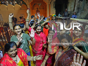 In Jaipur, Rajasthan, India, on November 15, 2024, people dance after lighting earthen lamps at the Shrine Galtaji temple holy pond 'kund' a...