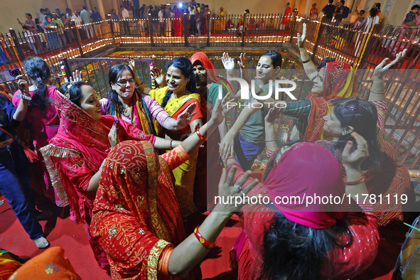 In Jaipur, Rajasthan, India, on November 15, 2024, people dance after lighting earthen lamps at the Shrine Galtaji temple holy pond 'kund' a...