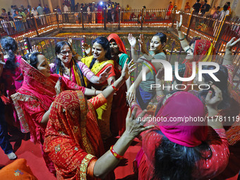 In Jaipur, Rajasthan, India, on November 15, 2024, people dance after lighting earthen lamps at the Shrine Galtaji temple holy pond 'kund' a...