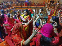 In Jaipur, Rajasthan, India, on November 15, 2024, people dance after lighting earthen lamps at the Shrine Galtaji temple holy pond 'kund' a...