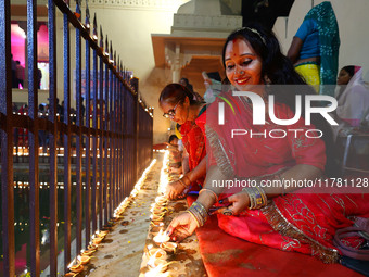 A woman lights earthen lamps at the Shrine Galtaji temple holy pond 'kund' as part of the Deep Mahotsav celebration on the eve of Dev Deepaw...