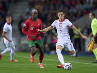 Kacper Urbanski of Poland is challenged by Nuno Mendes of Portugal during the UEFA Nations League 2024/25 League A Group A1 match between Po...