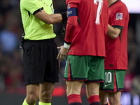 Referee Donatas Rumsas, Cristiano Ronaldo, and Bernardo Silva of Portugal discuss during the UEFA Nations League 2024/25 League A Group A1 m...