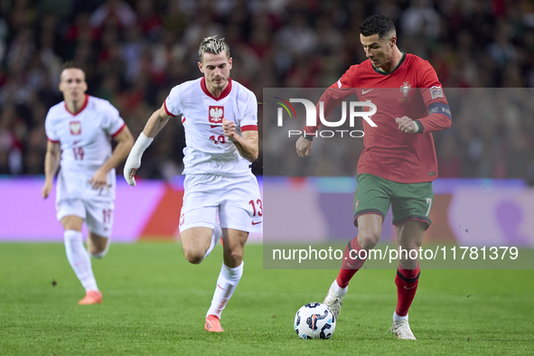 Cristiano Ronaldo of Portugal is challenged by Jakub Kaminski of Poland during the UEFA Nations League 2024/25 League A Group A1 match betwe...