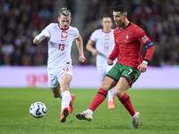 Cristiano Ronaldo of Portugal is challenged by Jakub Kaminski of Poland during the UEFA Nations League 2024/25 League A Group A1 match betwe...