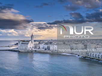 An aerial shot of the iconic Trani Cathedral, captured from the sea, highlights the Romanesque architecture of the cathedral, surrounded by...