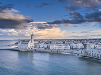 An aerial shot of the iconic Trani Cathedral, captured from the sea, highlights the Romanesque architecture of the cathedral, surrounded by...