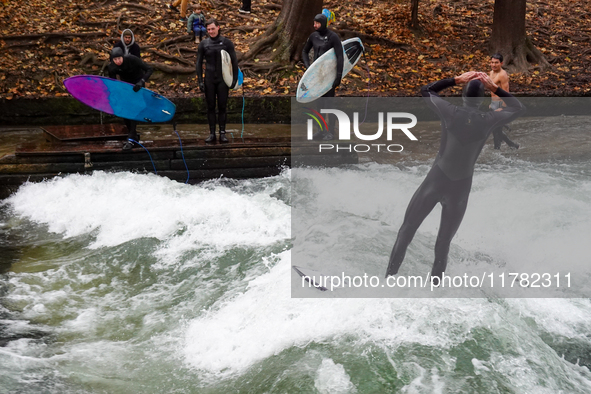 Surfers brave the icy waters of the Eisbach stream in Munich, Germany, on November 15, 2024. With temperatures at a brisk 5 degrees Celsius,...