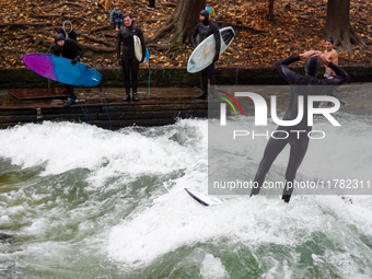 Surfers brave the icy waters of the Eisbach stream in Munich, Germany, on November 15, 2024. With temperatures at a brisk 5 degrees Celsius,...