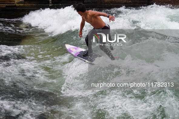 Surfers brave the icy waters of the Eisbach stream in Munich, Germany, on November 15, 2024. With temperatures at a brisk 5 degrees Celsius,...