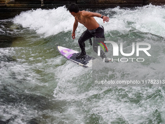 Surfers brave the icy waters of the Eisbach stream in Munich, Germany, on November 15, 2024. With temperatures at a brisk 5 degrees Celsius,...