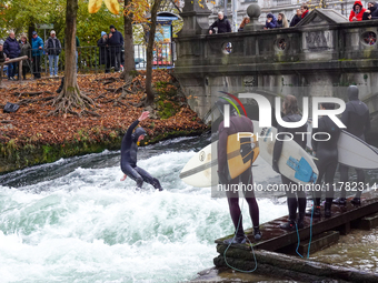 Surfers brave the icy waters of the Eisbach stream in Munich, Germany, on November 15, 2024. With temperatures at a brisk 5 degrees Celsius,...