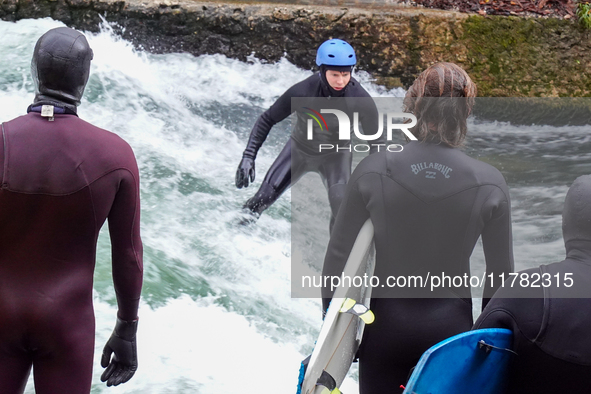 Surfers brave the icy waters of the Eisbach stream in Munich, Germany, on November 15, 2024. With temperatures at a brisk 5 degrees Celsius,...