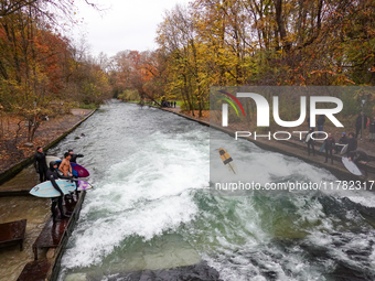 Surfers brave the icy waters of the Eisbach stream in Munich, Germany, on November 15, 2024. With temperatures at a brisk 5 degrees Celsius,...