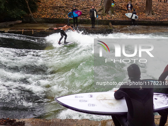 Surfers brave the icy waters of the Eisbach stream in Munich, Germany, on November 15, 2024. With temperatures at a brisk 5 degrees Celsius,...