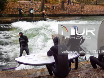 Surfers brave the icy waters of the Eisbach stream in Munich, Germany, on November 15, 2024. With temperatures at a brisk 5 degrees Celsius,...