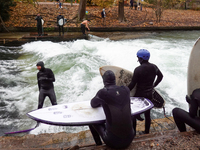 Surfers brave the icy waters of the Eisbach stream in Munich, Germany, on November 15, 2024. With temperatures at a brisk 5 degrees Celsius,...