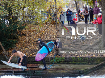 Surfers brave the icy waters of the Eisbach stream in Munich, Germany, on November 15, 2024. With temperatures at a brisk 5 degrees Celsius,...