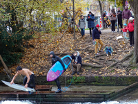 Surfers brave the icy waters of the Eisbach stream in Munich, Germany, on November 15, 2024. With temperatures at a brisk 5 degrees Celsius,...