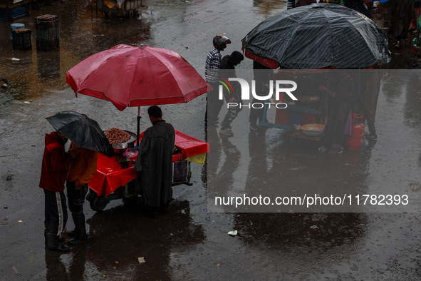 People use umbrellas as they walk amid heavy rainfall in Sopore, Jammu and Kashmir, India, on November 16, 2024. Higher reaches in Kashmir,...