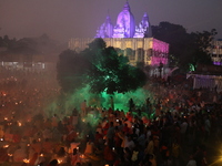 Hindu devotees sit together in front of oil lamps and pray to Shri Shri Loknath Brahmachari, a Hindu saint and philosopher, as they observe...