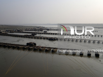 Labourers build a floating pontoon bridge across the river Ganges for devotees ahead of the upcoming Maha Kumbh 2025 festival in Prayagraj,...