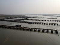 Labourers build a floating pontoon bridge across the river Ganges for devotees ahead of the upcoming Maha Kumbh 2025 festival in Prayagraj,...