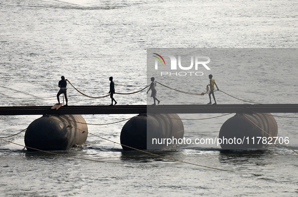 Labourers build a floating pontoon bridge across the river Ganges for devotees ahead of the upcoming Maha Kumbh 2025 festival in Prayagraj,...